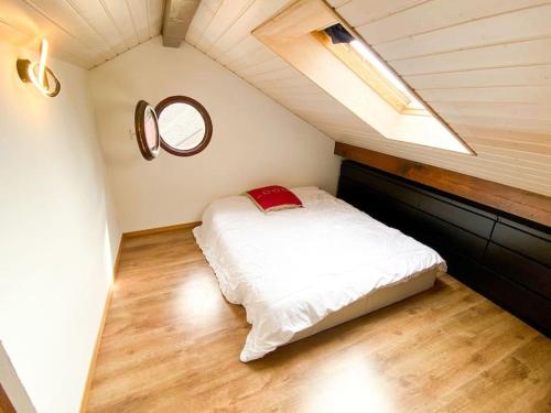 um quarto com uma cama branca num sótão em Appartement Duplex entre Genève et Lausanne em Saint-Livres