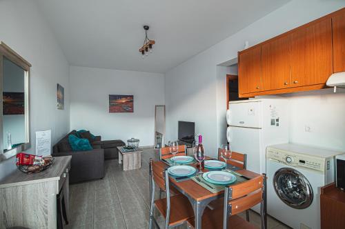 a kitchen and living room with a table and a refrigerator at Basiliki's Apartments in Archangelos