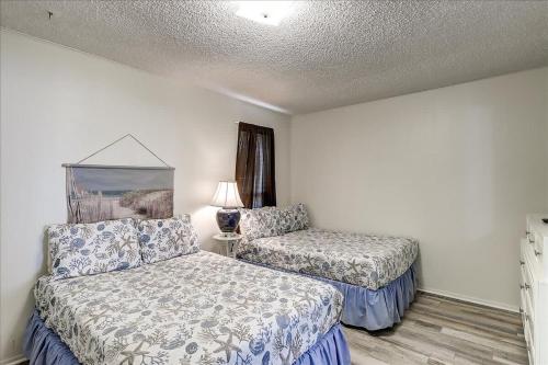 une chambre d'hôtel avec deux lits et une lampe dans l'établissement Pompano (Mustang Isle #20), à Port Aransas