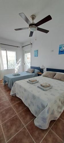a bedroom with two beds and a ceiling fan at Casa Isleta in La Manga del Mar Menor