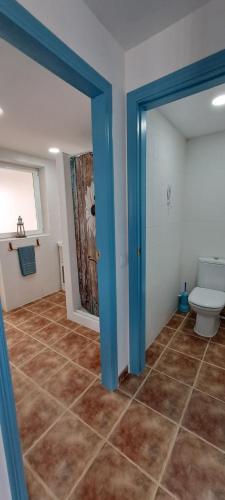 a bathroom with a toilet and a window and a doorway at Casa Isleta in La Manga del Mar Menor