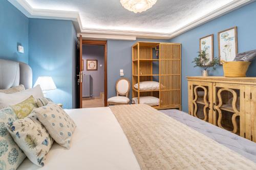 1 dormitorio con paredes azules y 1 cama en Dandy Villas Nymfaio - Snow Queen - Sauna - Fireplace - Up to 6 adults 2kids, en Nymfaio