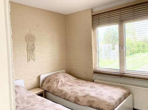 - une chambre avec 2 lits jumeaux et une fenêtre dans l'établissement NEW: Summerhouse near beach&lake, à Noordwijkerhout