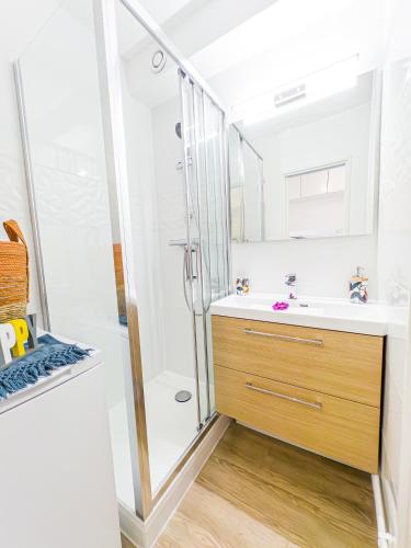 une salle de bain avec un lavabo et une douche dans l'établissement Horizon Piscine, Clim WIFI Parking Cosy 3min de l'étang top prosConciergerie, à La Grande Motte