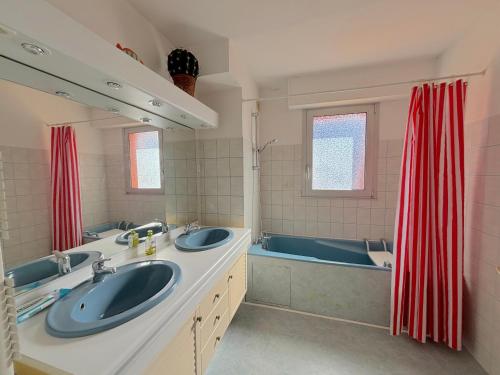 une salle de bain avec deux lavabos et une baignoire dans l'établissement Algues Roses, à Wimereux