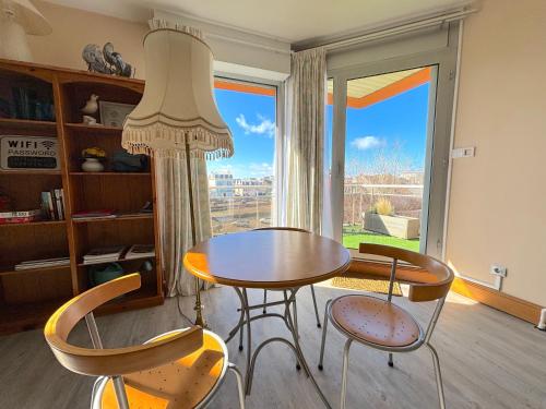 une table et des chaises dans une pièce avec une fenêtre dans l'établissement Algues Roses, à Wimereux
