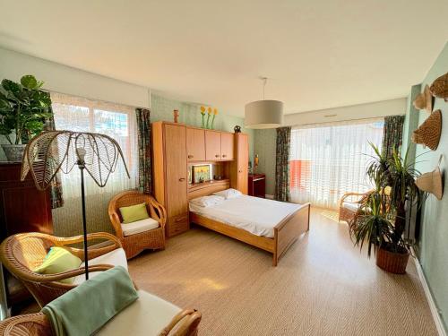 une chambre avec un lit et des chaises dans une pièce dans l'établissement Algues Roses, à Wimereux