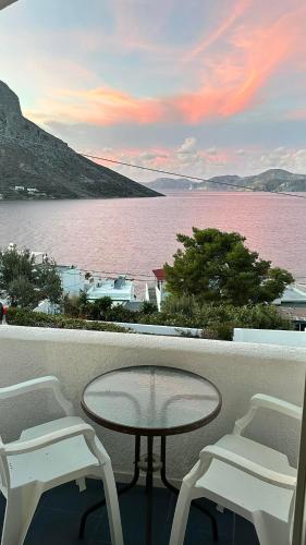 a table and chairs on a balcony with a view of the water at Elenis Studios&Apartments in Masouri