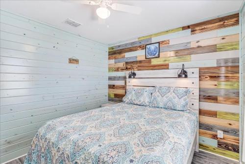 a bedroom with a bed and wooden walls at Blue Marlin Cottage (Anchor Courts #3) in Port Aransas