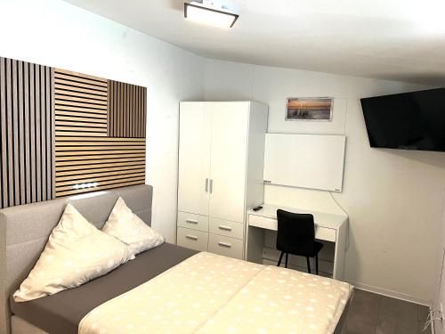 ein kleines Schlafzimmer mit einem Bett und einem Schreibtisch in der Unterkunft Messe 3 Minutes in Hannover