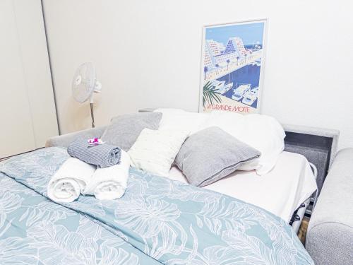 une chambre avec un lit avec des serviettes dessus dans l'établissement Horizon Piscine, Clim WIFI Parking Cosy 3min de l'étang top prosConciergerie, à La Grande Motte