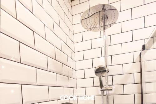 a white tiled wall with two shower heads at Gook Home CENTER in Jerez de la Frontera