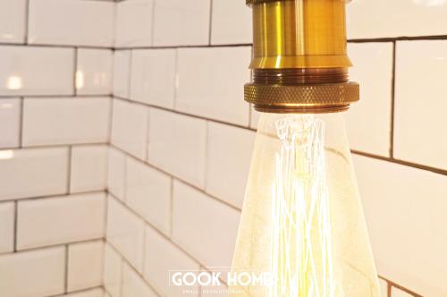 a glass bottle with a gold top on a tiled wall at Gook Home CENTER in Jerez de la Frontera