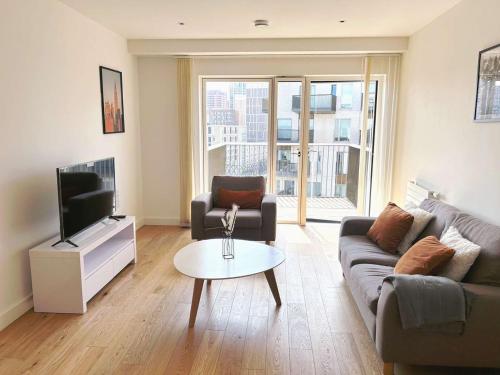 a living room with a couch and a tv and a table at Charming 1-Bed Apartment in London in London