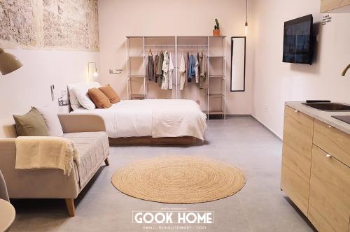 a bedroom with a bed and a couch and a kitchen at Gook Home CENTER in Jerez de la Frontera