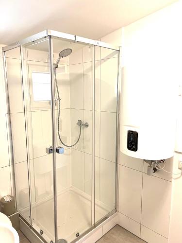 a shower with a glass enclosure in a bathroom at Messe 3 Minutes in Hannover