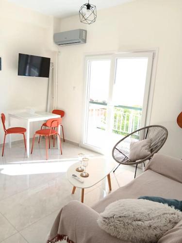 ein weißes Wohnzimmer mit einem Tisch und Stühlen in der Unterkunft Ilion apartments in Athen