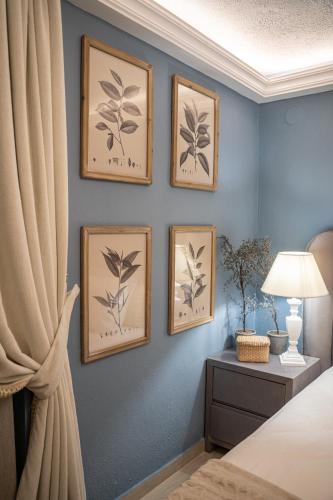a bedroom with three pictures on a blue wall at Dandy Villas Nymfaio - Snow Queen - Sauna - Fireplace - Up to 6 adults 2kids in Nimfaíon