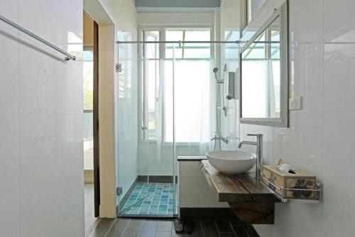 a bathroom with a sink and a glass shower at 花蓮綠舍 The Green Villa l 花蓮親子溜滑梯民宿 in Pinghe