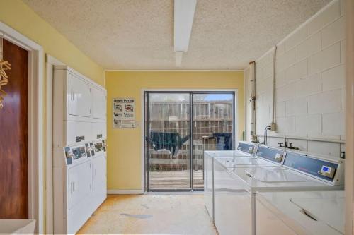 a kitchen with yellow walls and white appliances at Fish Station Bike Rack BBQ Golf Cart Access in Port Aransas