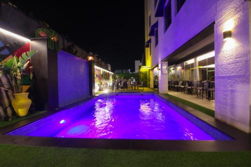 a swimming pool with purple lights in a building at Monarch Hotel Amman in Amman