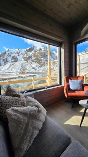 a living room with a view of a snow covered mountain at Hemmingodden Lodge in Ballstad