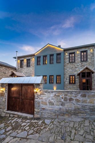 a large house with a garage in front of it at Dandy Villas Nymfaio - Snow Queen - Sauna - Fireplace - Up to 6 adults 2kids in Nimfaíon