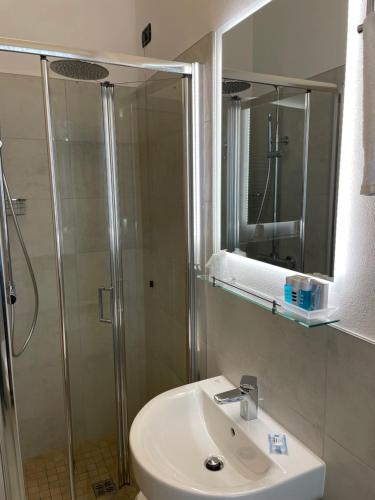 a bathroom with a shower and a sink and a mirror at Hotel Villa Rosa in Sirmione