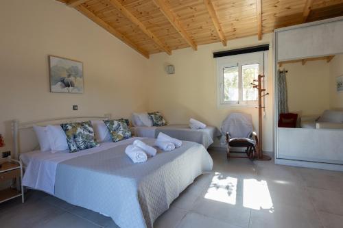 a bedroom with two beds and a couch at RELAXING POOL HOUSE IN LAGONISI 2 in Kalívia Thorikoú