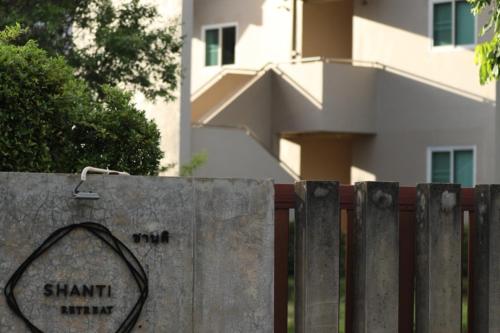 un cartel en una valla delante de un edificio en Shanti-Retreat Hotel, en Pua