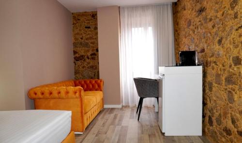 a hotel room with a couch and a chair at Lux'Otel City Lodge in Barcelos