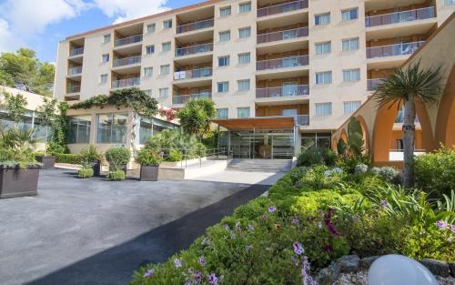 un edificio de apartamentos con un patio con plantas en Hotel Atlantic by Hoteles Centric en Es Cana
