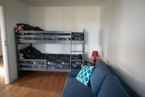 uma sala de estar com um sofá azul e beliches em NCNK Lawendowy Domek em Iława