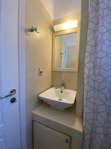 ein Bad mit einem Waschbecken und einem Spiegel in der Unterkunft SEAVIEW UP in Korissia