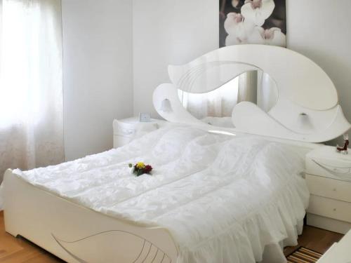 una cama blanca con una flor encima en 3 bedrooms villa with private pool enclosed garden and wifi at Umag 1 km away from the beach, en Umag