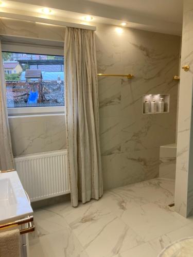 a bathroom with a large marble shower with a window at Golden Rooms in Völkermarkt