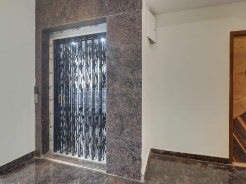 OYO Hotel Shannu Grand في حيدر أباد: باب في جدار مع شبك معدني