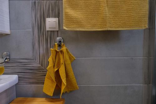 a bathroom with yellow towels hanging on a wall at sophia's apartment in Volos