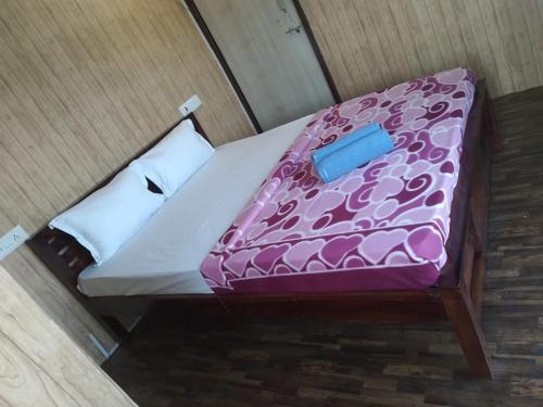 ein Bett mit einer lila Decke darüber in der Unterkunft AANDRA LAKESTAY RESORT CAMPZONE in Takwa Budrukh