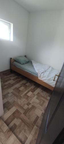 een bed in een kamer met een houten vloer bij SanStill in Batajnica