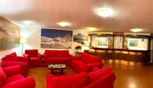 a living room with red couches and a table at Cervinia Due in Breuil