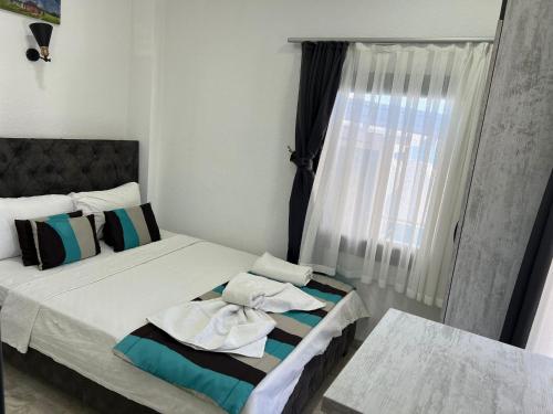 a bedroom with a bed and a window at Tiana Butik Otel in Bodrum City