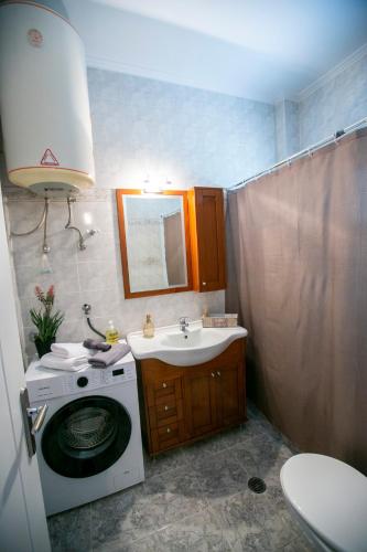 a bathroom with a washing machine and a sink at Bay Maisonette in Iraklitsa