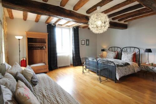 a living room with two beds and a chandelier at Jallanges in Fontevraud-l'Abbaye