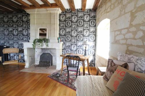 a living room with a fireplace and a stone wall at Jallanges in Fontevraud-l'Abbaye