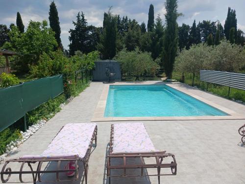 une piscine avec deux chaises longues à côté dans l'établissement Gite La CRAU & piscine - Oliveraie Bio Mas de Cargane, à Entressen