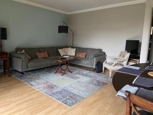 un salon avec un canapé et une table dans l'établissement Confortable 3 pièces 75m2, Vincennes Centre, à Vincennes