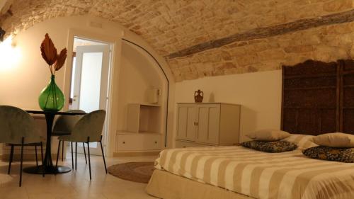 sypialnia z łóżkiem i stołem w pokoju w obiekcie Le Badesse Mitrate by il pumo di puglia w mieście Conversano