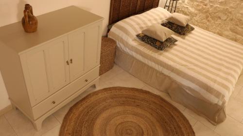 a bedroom with a bed with a cabinet and a rug at Le Badesse Mitrate by il pumo di puglia in Conversano