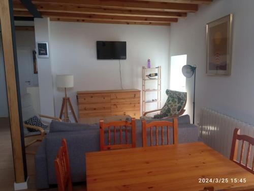 a living room with a blue couch and a table at Casa Rural - De Brevas a Higos in Espirdo